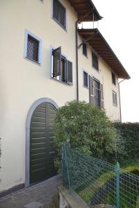 een wit huis met een zwarte deur en een hek bij 10 minuti dall'areoporto Orio al Serio BGY in Zanica