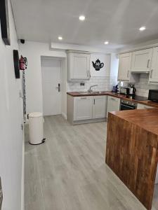 a kitchen with white cabinets and a wooden floor at Number33 in Galway