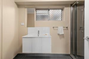 ein Bad mit einem Waschbecken und einer Dusche in der Unterkunft S1 Motel in Brisbane