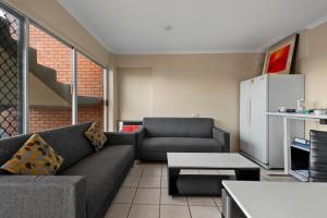 ein Wohnzimmer mit einem Sofa und einem Tisch in der Unterkunft S1 Motel in Brisbane
