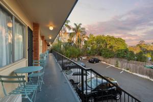 einen Balkon mit Tischen und Stühlen sowie einen Parkplatz in der Unterkunft S1 Motel in Brisbane