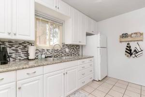 een witte keuken met een wastafel en een koelkast bij Casa Amore -2BR- FREE Driveway parking for 3 cars in San Diego