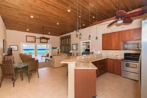 a kitchen with a dining room and a living room at Peaceful Ocean Front Beach House in Bodden Town in Bodden Town