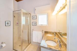 a bathroom with two sinks and a shower at Peaceful Ocean Front Beach House in Bodden Town in Bodden Town