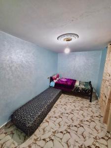 une chambre avec un lit dans l'angle d'une pièce dans l'établissement Résidence SEHRAWILOCATION, à Errachidia