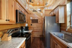 cocina con armarios de madera y nevera de acero inoxidable en New Lux Cabin Hot Tub FirePit Games, 