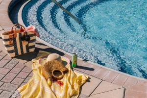 a hat and a towel next to a swimming pool at Sonder at Vista Cay in Orlando