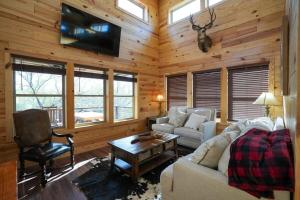 Cabaña con sala de estar con sofá y TV. en Exquisite Modern Lux Cabin Hot Tub FirePit Games, 