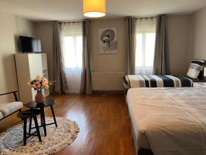 a bedroom with a bed and a table with flowers on it at Gite le Saint André in Villers-sur-Port