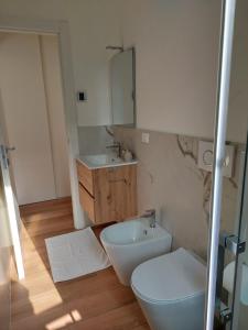 uma casa de banho com um lavatório, um WC e um espelho. em Casa Mappamondo em Lecco