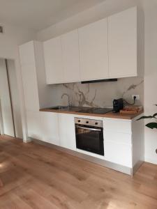 a white kitchen with white cabinets and a sink at Casa Mappamondo in Lecco