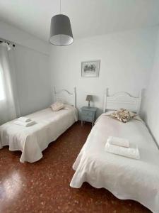 a bedroom with two beds and a table with a lamp at Nice central flat with wonderful views in Córdoba