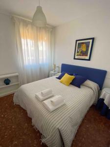 a bedroom with a blue and white bed with towels on it at Nice central flat with wonderful views in Córdoba