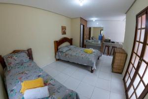 Cet appartement comprend une chambre avec un lit et une cuisine. dans l'établissement Casa 3/4 aconchegante no Vale do Capão, à Palmeiras
