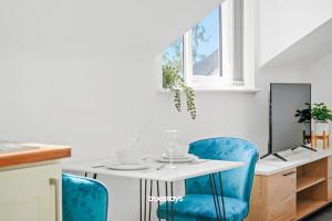 a dining room with a table and blue chairs at 6 Sarah House by Truestays - 2 Bedroom Apartment - FREE Wifi & Parking in Manchester