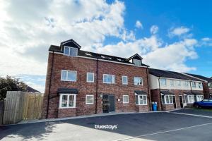 a red brick building with white windows on a street at 6 Sarah House by Truestays - 2 Bedroom Apartment - FREE Wifi & Parking in Manchester