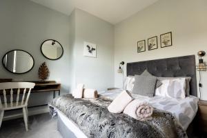 1 dormitorio con cama, mesa y espejos en LITTLE RED HOLIDAY HOME - 2 Bed House with Free Parking within West Yorkshire, local access to the Peak District, en Halifax