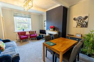uma sala de estar com mesa e cadeiras em LITTLE RED HOLIDAY HOME - 2 Bed House with Free Parking within West Yorkshire, local access to the Peak District em Halifax