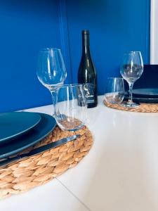 tres copas de vino en una mesa con una botella de vino en Le Quai Saint Laurent - BY PRIMO C0NCIERGERIE, en Orléans