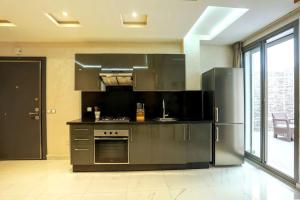 a kitchen with stainless steel appliances and a large window at Résidence Sheren - Maarif in Casablanca