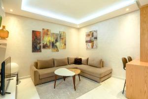 a living room with a couch and paintings on the wall at Résidence Sheren - Maarif in Casablanca +10 photos