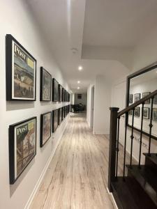 a hallway with a bunch of framed pictures on a wall at Luxury Executive Studio in Oakville