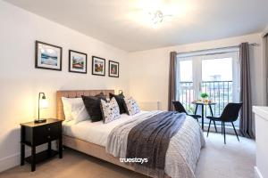 a bedroom with a bed and a table and a window at Ambassador House by Truestays - Luxury 4 Bedroom House in Stoke-on-Trent in Etruria