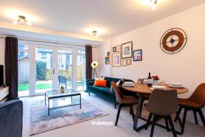 Etruria的住宿－Ambassador House by Truestays - Luxury 4 Bedroom House in Stoke-on-Trent，客厅配有桌子和绿色沙发