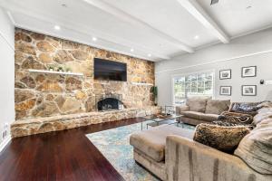 a living room with a stone wall with a fireplace at Mansion With Private Pool Basketball & Tennis courts in Fayetteville