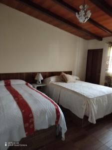 twee bedden naast elkaar in een slaapkamer bij Quinta imperio del sol in Latacunga