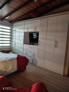 um quarto com uma cama e uma televisão de ecrã plano em Quinta imperio del sol em Latacunga