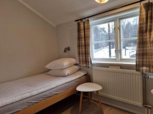 a small bedroom with a bed and a window at Sofielund Vandrarhem & Camping in Sala