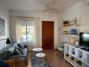 a living room with a couch and a television at Casa Montana tranquilidad en la Costa Cálida in Mazarrón