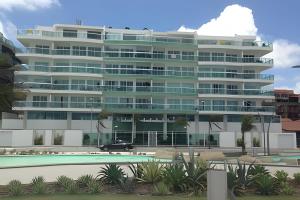 a large building with a pool in front of it at PRAIA DO FORTE ALTO LUXO in Cabo Frio