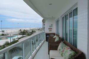 a balcony with chairs and a view of the beach at PRAIA DO FORTE ALTO LUXO in Cabo Frio