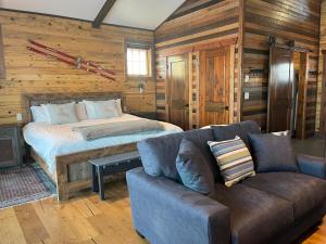 a bedroom with a bed and a couch in a room at New Cabin with Spectacular Views of Flathead Lake. in Somers
