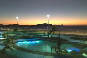 a view of a swimming pool at sunset at PRAIA DO FORTE ALTO LUXO in CFB