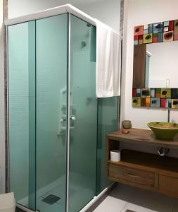 a glass shower in a bathroom with a sink at PRAIA DO FORTE ALTO LUXO in Cabo Frio