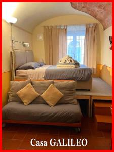a bedroom with two beds and a bench in front of a window at Casa GALILEO- Antiche Dimore Pisane in Pisa +23 photos