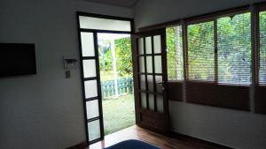 une porte ouverte menant à une chambre avec fenêtre dans l'établissement Hostal Suna Vito, à Puerto Asís