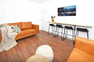 a living room with a couch and a bar with stools at Gilman House by Truestays - 4 Bedroom House in Stoke-on-Trent in Etruria