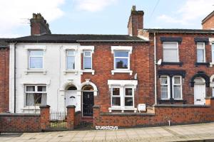 ein Backsteinhaus mit weißen Türen und Fenstern in der Unterkunft Gilman House by Truestays - 4 Bedroom House in Stoke-on-Trent in Etruria