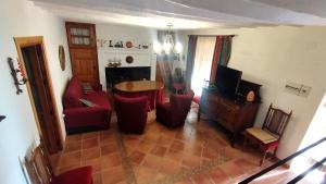 uma sala de estar com uma mesa e cadeiras vermelhas em Casa Rural La Solana em Benamaurel