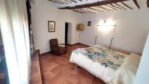 um quarto com uma cama e uma cadeira num quarto em Casa Rural La Solana em Benamaurel