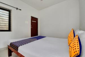 a bedroom with a bed with blue and orange pillows at SPOT ON U & I Livings in Arambol