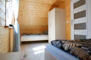 a bedroom with two beds in a wooden cabin at Domki Rejs in Dębki