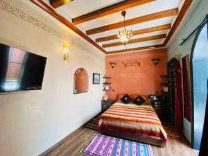 - une chambre avec un lit et une télévision à écran plat dans l'établissement Traditional house (Riad) in the heart of Rabat medina, à Rabat