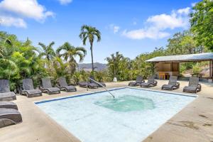 a swimming pool with chaise lounges and chairs at Peaceful Garden Villa in Sardinal
