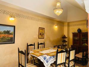 uma sala de jantar com uma mesa e cadeiras e um lustre em Traditional house (Riad) in the heart of Rabat medina em Rabat