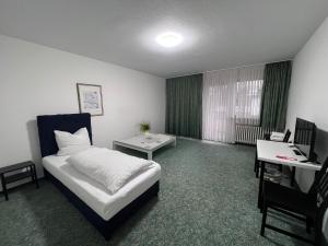 een hotelkamer met een bed, een bureau en een computer bij Haven - Hotel Am Stadion in Leverkusen